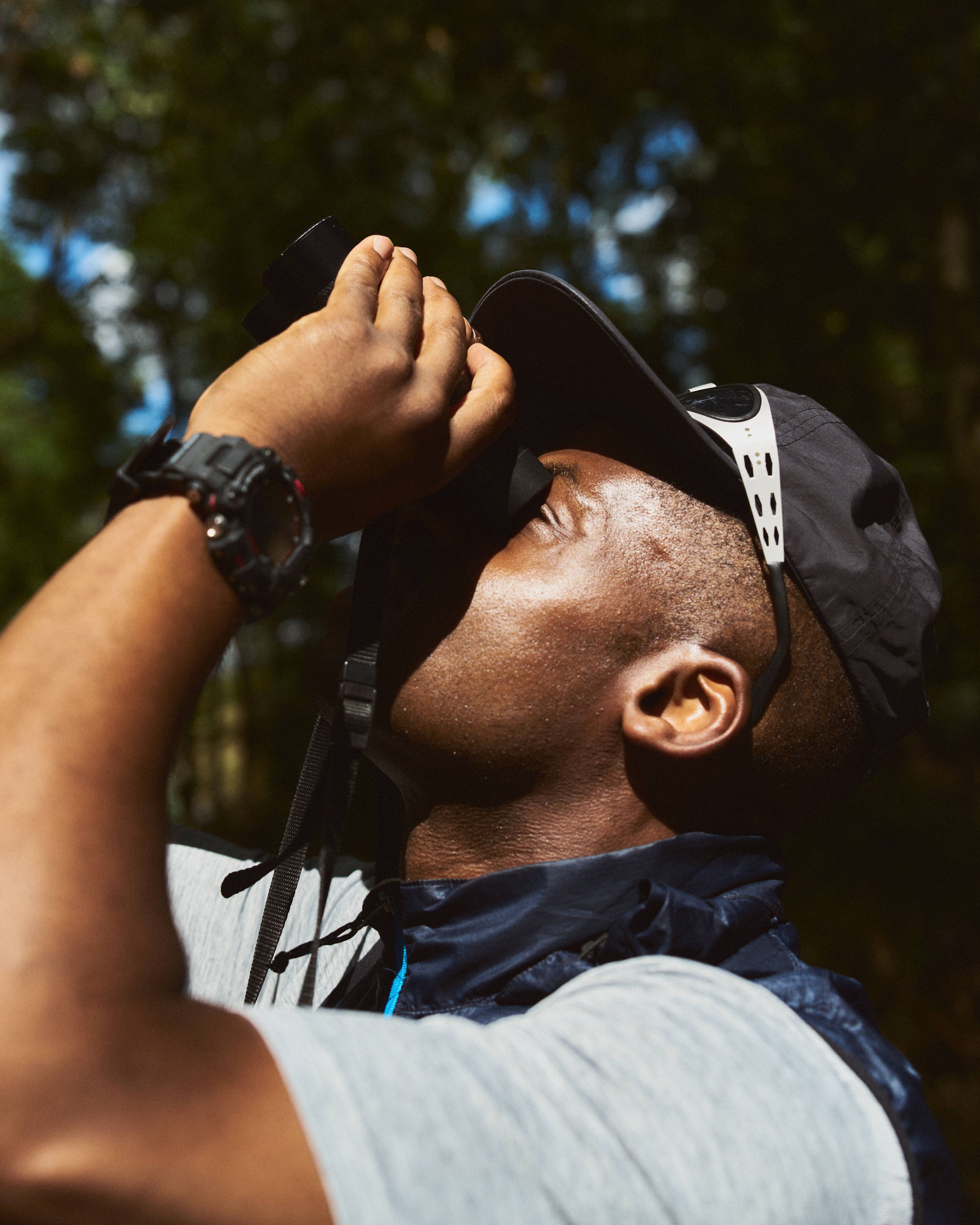 A man looking up at the sky through binoculars